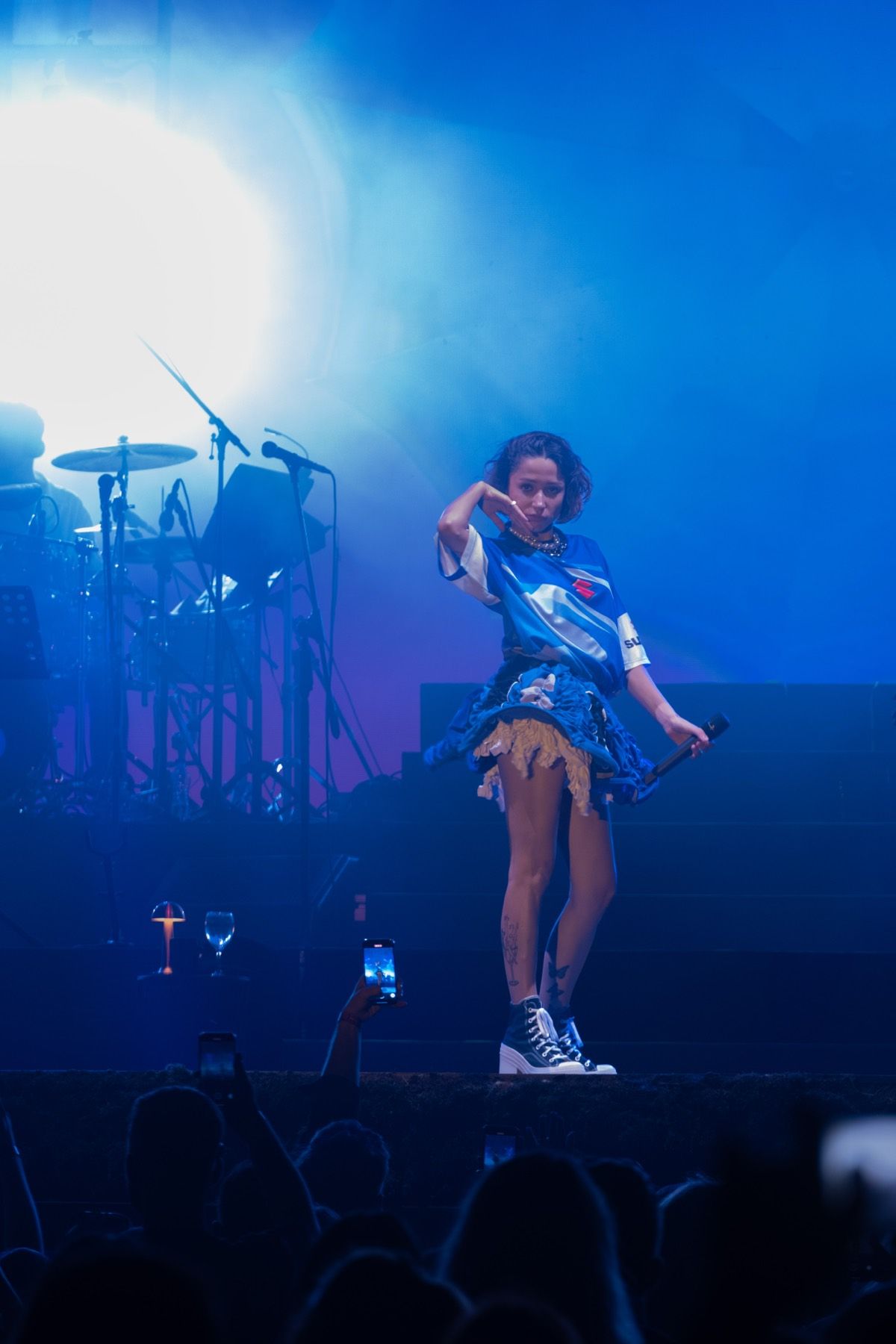 A performer illuminated by blue stage lights